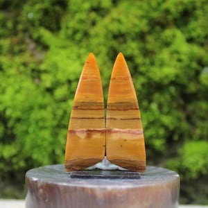 May include: Two pointed, yellow, brown, and red striped stone bookends.