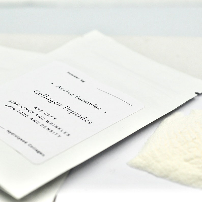 Peut inclure: Une pochette blanche avec le texte "Active Formulas Collagen Peptides" et "AGE DEFY FINE LINES AND WRINKLES SKIN TONE AND DENSITY" imprim&eacute; dessus. La pochette contient une poudre blanche.