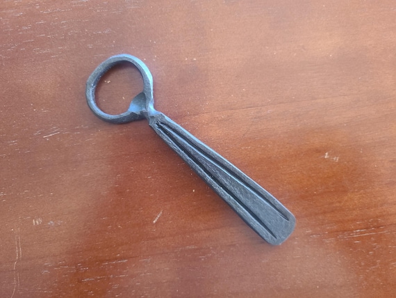 Forged-by-hand bottle opener with visible hammer marks — a tactile, rustic piece of functional blacksmithing that feels genuinely one-of-a-kind.