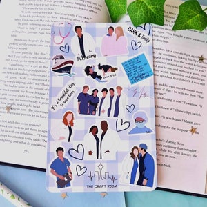 May include: A set of 10 Grey's Anatomy themed stickers featuring characters from the show. The stickers are on a blue and white checkered background. The stickers include the characters Meredith Grey, Derek Shepherd, Cristina Yang, Alex Karev, Miranda Bailey, Richard Webber, and Owen Hunt. The stickers also include the text "It's a beautiful day to save lives" and "The Craft Room".