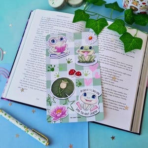 May include: A set of four frog-themed stickers with a green and white chequered background. The stickers feature frogs in various poses, including reading a book, sitting on a lily pad, and jumping into the next chapter. The stickers are perfect for adding a touch of whimsy to your planner, journal, or laptop.
