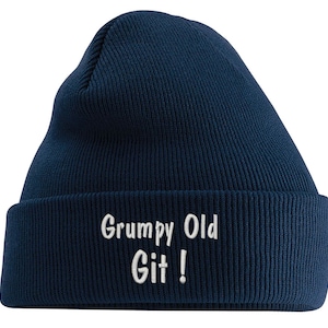 Puede incluir: Un gorro de punto azul marino con el texto bordado en blanco "Grumpy Old Git!"