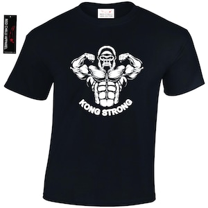 May include: Black t-shirt featuring a white graphic of a gorilla flexing its muscles. The text "KONG STRONG" is below the gorilla. The shirt has a crew neck and short sleeves. The brand name "RED CHILLI APPAREL" is on a tag.
