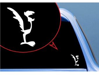 May include: A white vinyl decal of the Road Runner cartoon character applied to a dark vehicle window. The design features the bird in a standing profile position with its signature crest and long tail feathers, shown in a magnified circular view.