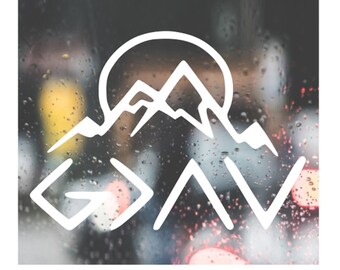 May include: White vinyl decal with a mountain range and a sun behind it. The mountains are stylized to look like the letters "G A V" with the "G" being a mountain peak and the "A" and "V" being two mountain peaks.