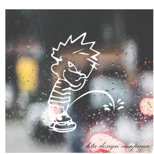 May include: A white outline drawing of a cartoon boy peeing on a window. The background is blurry and shows out-of-focus lights.