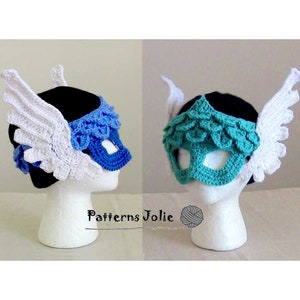 May include: Two crocheted masks with white wings. One mask is blue and the other is teal.