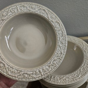 May include: A set of six gray ceramic bowls with an ornate floral design around the rim.