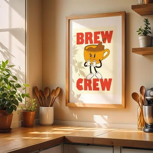 May include: A framed print with the words "BREW CREW" in red, featuring a cartoon coffee cup character. The image is in a kitchen setting with plants, wooden spoons, and a coffee maker.