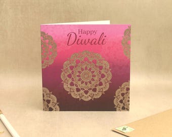May include: A square greeting card with a pink to dark purple gradient background. The card features gold mandala patterns and the text Happy Diwali printed in a dark purple script font centered at the top of the card design.