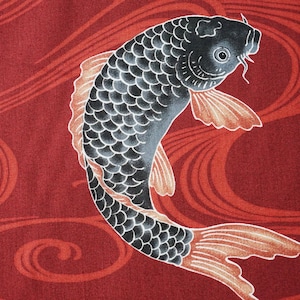 May include: A black and white koi fish with orange fins swimming in a red and white wave pattern.