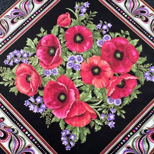 May include: A square textile featuring a central floral arrangement of vibrant red poppies and small purple flowers on a black background. The design is framed by a decorative border with paisley and dot patterns in white, red, and purple.
