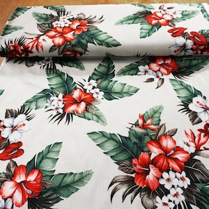 May include: White fabric with a tropical print featuring red hibiscus flowers, green leaves, and white flowers.