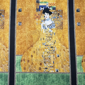 May include: Fabric panel featuring a reproduction of Gustav Klimt's "Portrait of Adele Bloch-Bauer I." The artwork showcases a woman in a gold dress with intricate patterns, set against a gold background. Black borders frame the image, with green and black accents.