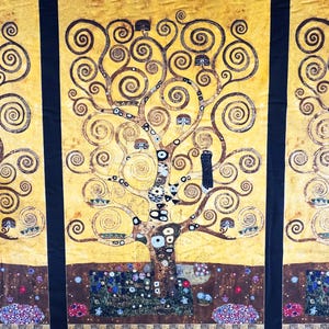 May include: A fabric panel featuring a stylized tree design with swirling branches and spiral leaves. The artwork has a gold and brown color palette with black borders. The tree is set against a yellow background with a decorative border at the bottom.