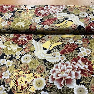 May include: Black fabric with a gold and red floral pattern. The pattern features cranes, peonies, and cherry blossoms.