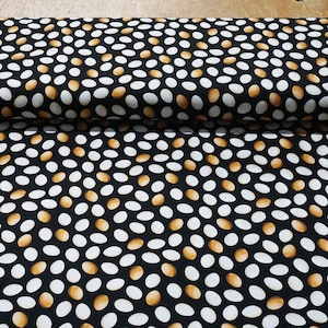 May include: Black fabric with a repeating pattern of white and brown eggs. The eggs are scattered randomly across the fabric.