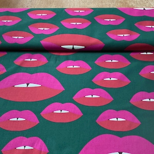 Può includere: Tessuto verde con un motivo ripetitivo di labbra rosa e rosse.
