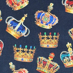 May include: A fabric pattern featuring various ornate crowns in gold, red, blue, and green, set against a dark blue background. The crowns are detailed with jewels and intricate designs, suggesting a royal or regal theme.
