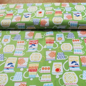 May include: Green fabric with a repeating pattern of colourful teapots and mugs. The teapots and mugs are stylised and have a retro look.