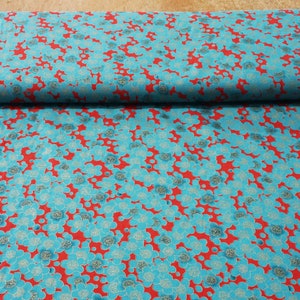 以下が含まれることがあります： 赤地にターコイズブルーの花柄の生地。花は生地にランダムに散りばめられており、金色のグリッターのアクセントが施されています。
