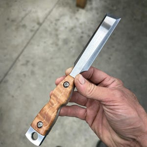 May include: A small, hand-crafted knife with a wooden handle and a silver blade. The handle is made of a light brown wood with a natural grain pattern. The blade is sharp and has a slight curve to it.