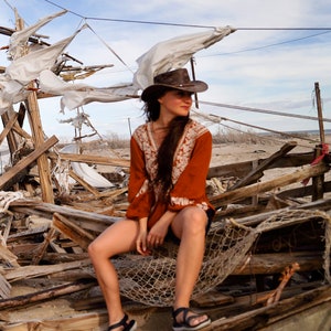 woman wearing a Foldable leather hat - brown the wilds from wombat