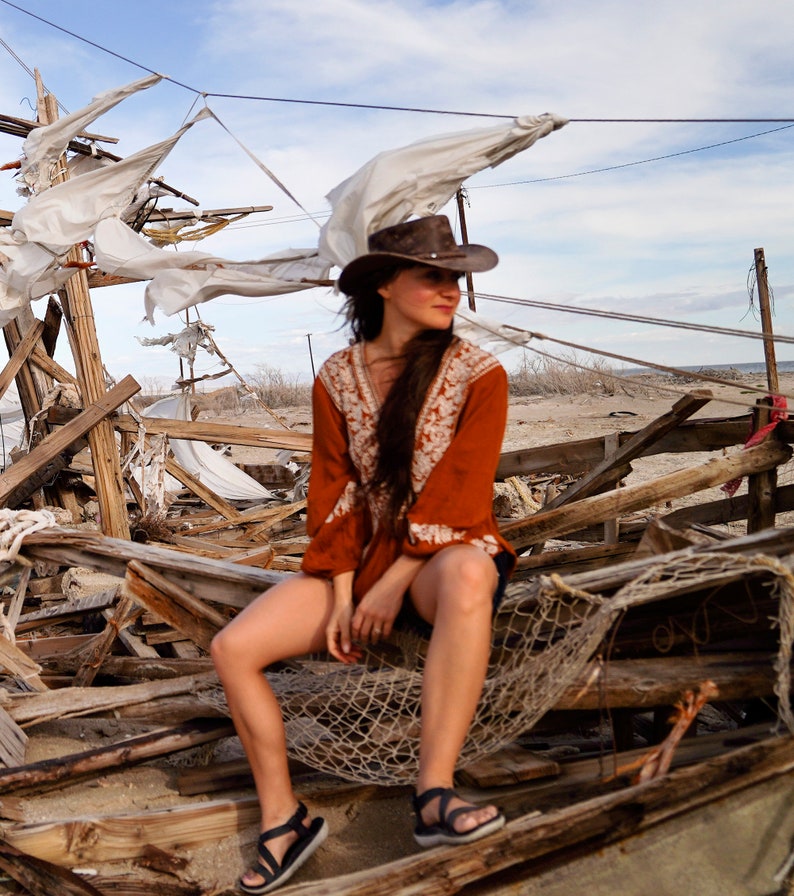 woman wearing a Foldable leather hat - brown the wilds from wombat