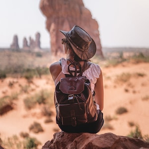 woman wearing a Foldable leather hat - brown the wilds from wombat