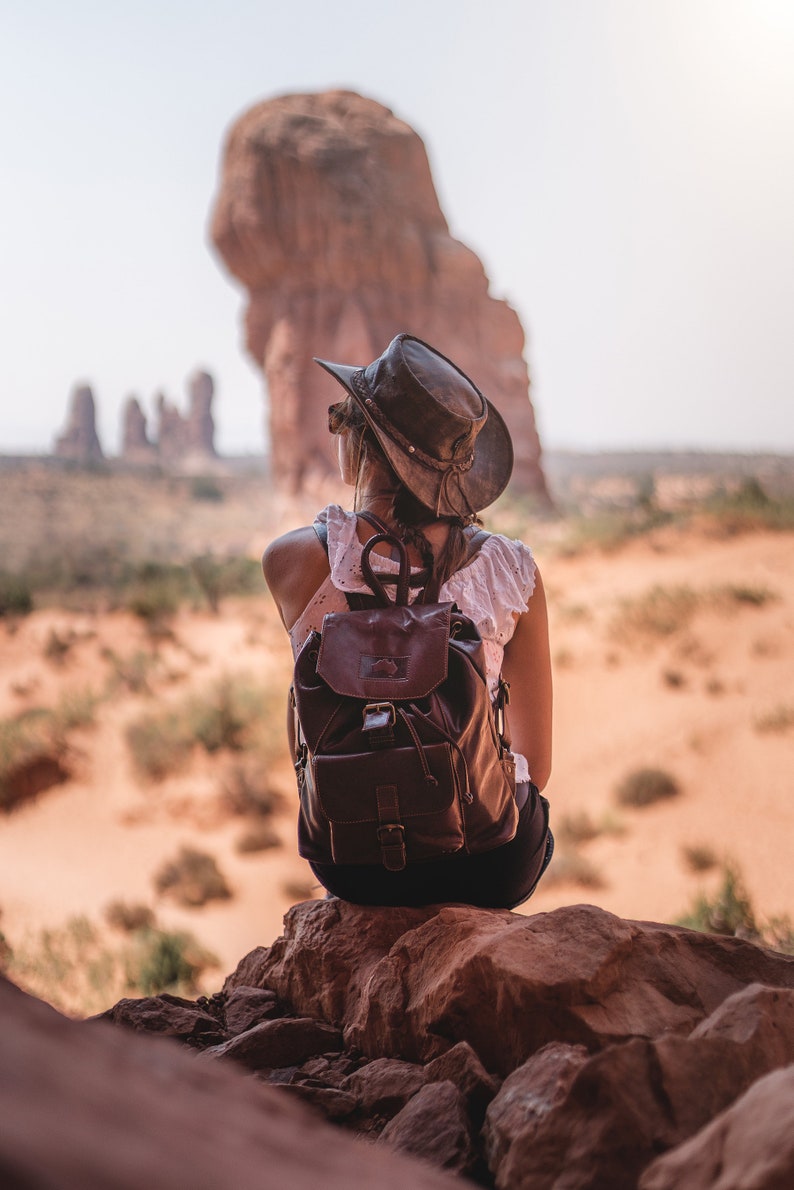 woman wearing a Foldable leather hat - brown the wilds from wombat