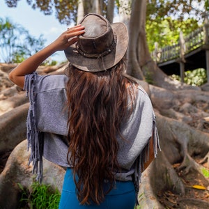 woman wearing a Foldable leather hat - brown the wilds from wombat