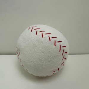 以下が含まれることがあります： 赤いステッチが付いた白いぬいぐるみ野球