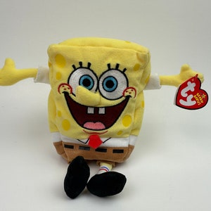 May include: Yellow plush Spongebob Squarepants Beanie Baby with a red tie and a white shirt. The Beanie Baby has a red tag that says "Ty Beanie Babies".