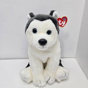 May include: A white and gray plush husky dog toy with blue eyes. The toy has a red heart-shaped tag with the word "ty" on it.