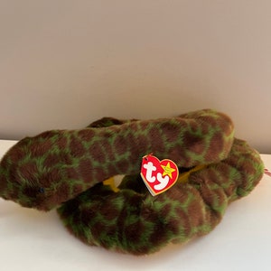 May include: Green and brown snake plush toy with a red tongue. The snake is curled up and has a red Ty tag with a white star.
