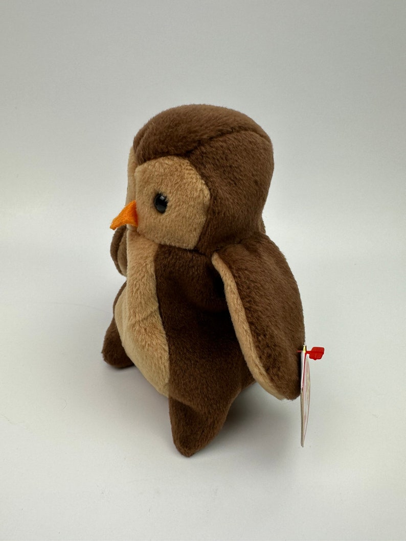 K&ouml;nnte beinhalten: Brauner und beiger Pl&uuml;sch-Eule mit einem kleinen orangefarbenen Schnabel. Die Eule hat ein Ty-Etikett an ihrem Fl&uuml;gel.