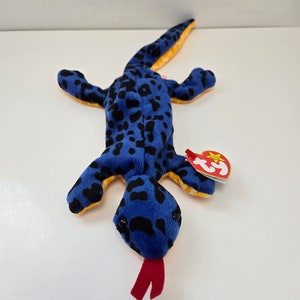 May include: Blue and black spotted plush toy lizard with a red tongue and a Ty tag attached.
