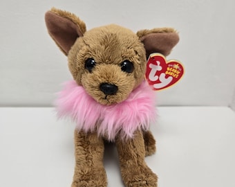Puede incluir: Chihuahua de peluche marrón y beige con un collar de piel rosa. El juguete de peluche tiene ojos negros y una nariz negra. El juguete tiene una etiqueta de Ty Beanie Babies unida a su oreja.