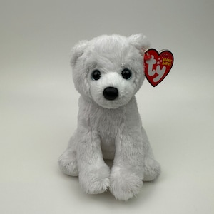 Puede incluir: Oso polar de peluche blanco sentado con una etiqueta roja Ty Beanie Babies unida a su oreja.