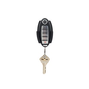 May include: Black key fob with a silver button panel and the Nissan logo. The key fob is attached to a silver key ring with a house key.