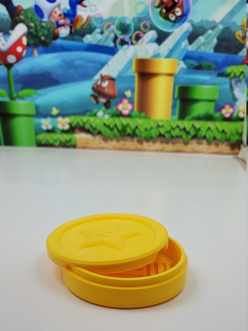 May include: A yellow, round, two-piece container with a star design on the lid. The container is made of plastic and is about 3 inches in diameter.