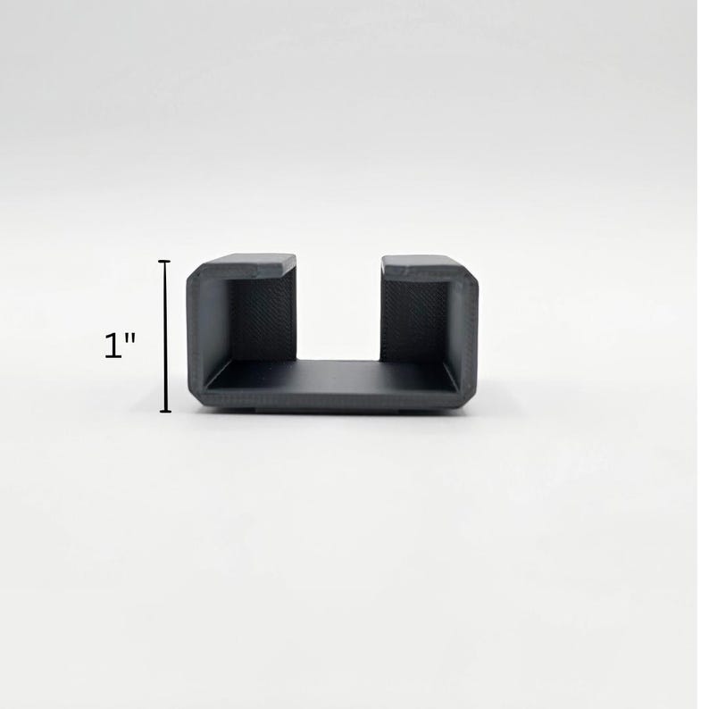 May include: A black plastic U-shaped bracket, measuring 2.5 cm in height.