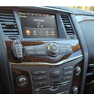 May include: A car's dashboard with a touchscreen display showing "Not Provided" and a time of 11:48. The dashboard has buttons for radio, media, disc, camera, navigation, apps, status, climate, volume, and more.