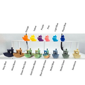May include: A collection of small, colorful boat models in various shades including orange, yellow, purple, pink, light blue, and royal blue. Additional colors are navy blue, wood brown, green red gold, gold green black, blue orange green, muted blue, muted green, and sandstone.