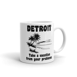 Könnte beinhalten: Weiße Keramiktasse mit einer schwarzen Silhouette von Palmen und dem Text "DETROIT Machen Sie Urlaub von Ihren Problemen".