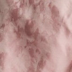 May include: A pink and white tie-dye fabric with a subtle floral pattern.