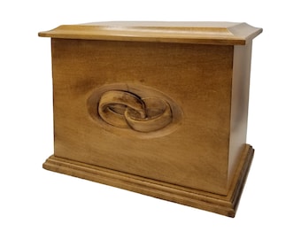 May include: A wooden box with a carved design of two intertwined rings. The box is a light brown color and has a simple, elegant design.