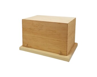May include: A wooden box with a light brown finish and a slightly lighter base. The box has a simple, rectangular shape and is made of solid wood.