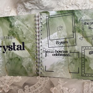 May include: A spiral-bound anniversary scrapbook page with a green crystal pattern background. The text reads YEAR FIFTEEN crystal, 15 years, the year is, how we celebrated, and gifts. It includes black line-drawn frames for photos and notes.