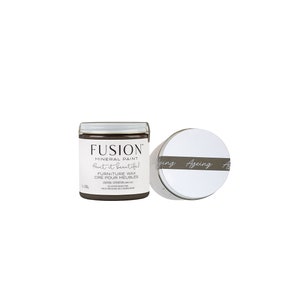 May include: A brown jar of Fusion Mineral Paint labeled "Paint it beautiful" with a white lid. The jar is labeled "Furniture Wax - Cire Pour Meubles".